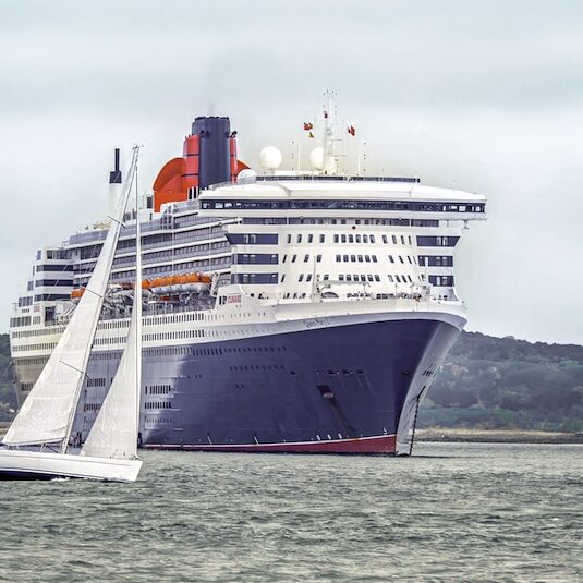 Queen Mary 2 mit Segelboot davor